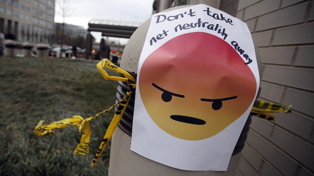 Une affiche avec un émoticône en colère et le message « N'enlevez pas la neutralité d'Internet » a été placée à l'extérieur des bureaux de la Federal Communications Commission (FCC) à Washington jeudi.