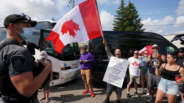 Protesters scream as police secure the property while Liberal Leader Justin Trudeau gets ready to announce green incentives towards climate change at a stop during the federal election campaign in Cambridge, Ont., on Aug. 29, 2021. 