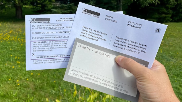 Hawak ng isang kamay ang voting kit.