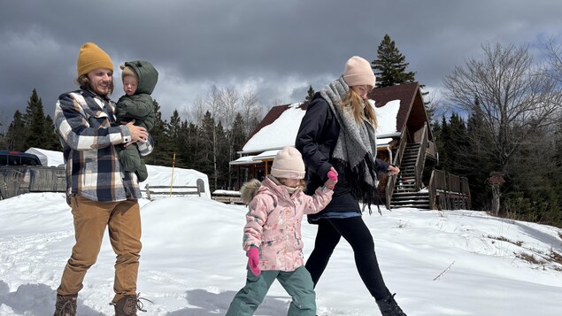 Romain, Nadia et leurs enfants marchent dans la neige. 