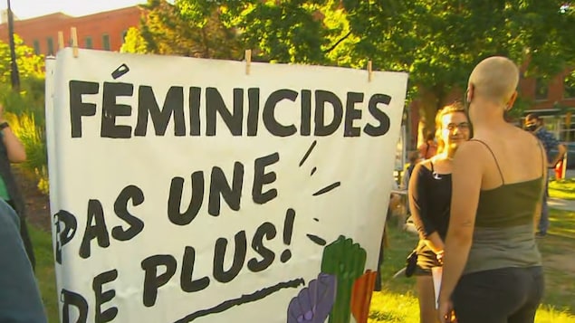 Des personnes avec une pancarte.