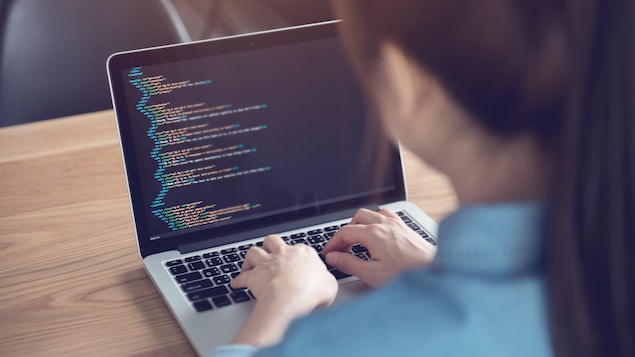 Une femme entrain de coder.