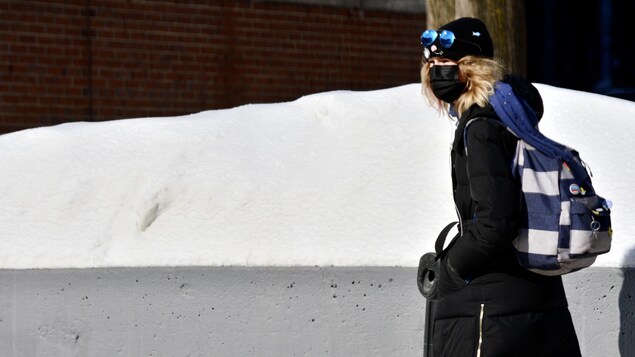 Une femme portant un couvre-visage dans les rues de Montréal.