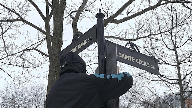 Un membre de l’équipe change les plaques toponymiques pour éviter un anachronisme.