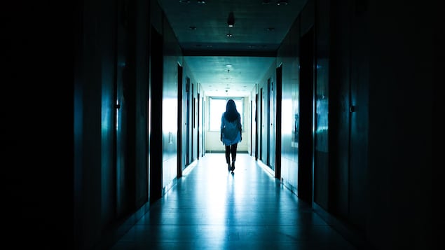Une jeune femme seule dans un tunnel sombre.