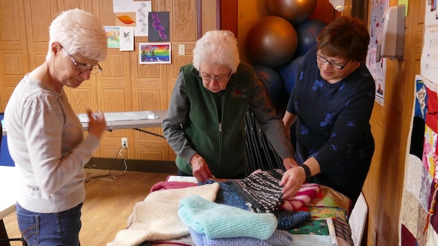 Alma Lagassé, Laurette Aubin, Alice Devos examinent les châles et les courtepointes qui sont prêts à être offert aux résidents des maisons de soins. Alma Lagassé, Laurette Aubin, Alice Devos examinent les châles et les courtepointes qui sont prêts à être offert aux résidents des maisons de soins.