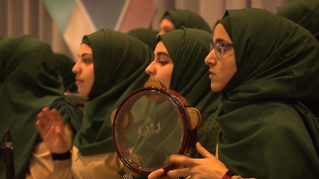 Des femmes musulmanes voilées jouent avec des instruments de musique lors d'un rassemblement dans une salle de réception à Laval.