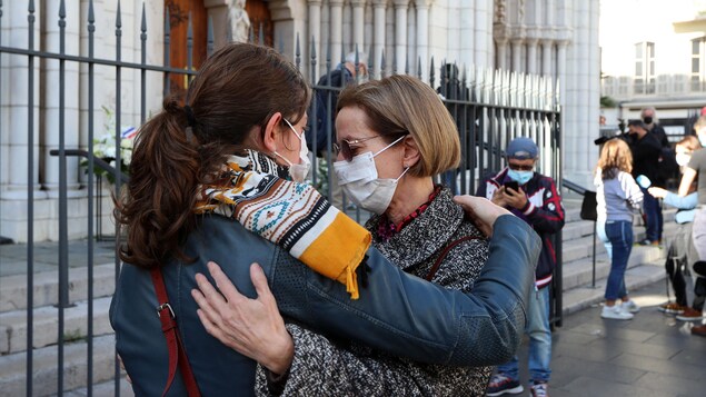 Deux femmes se tiennent par les épaules.