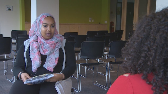 Une femme dont la tête est couverte d'un voile accorde une entrevue à une journaliste Une femme dont la tête est couverte d'un voile accorde une entrevue à une journaliste