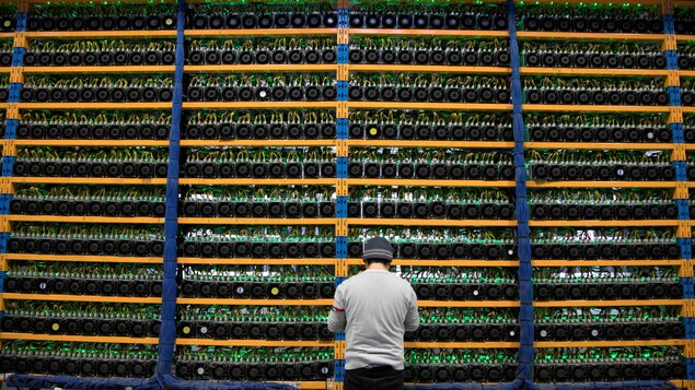 Un ouvrier vérifie les ventilateurs sur les mineurs, à l'exploitation agricole cryptocurrency, Bitfarms, à Farnham.