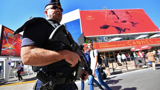Un policier monte la garde devant le Palais des Festivals à Cannes Un policier monte la garde devant le Palais des Festivals à Cannes
