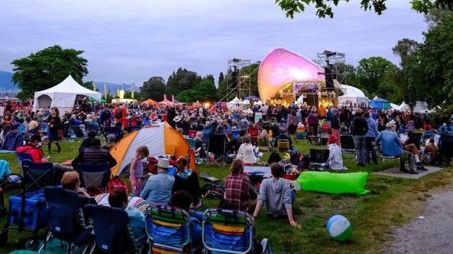 Des spectateurs assis sur des chaises ou par terre devant la scène principale du Festival de musique folk de Vancouver