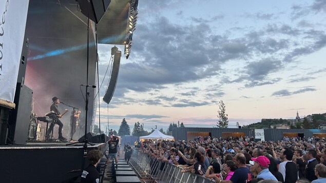 Une foule de personnes qui assistent à un spectacle extérieur. 