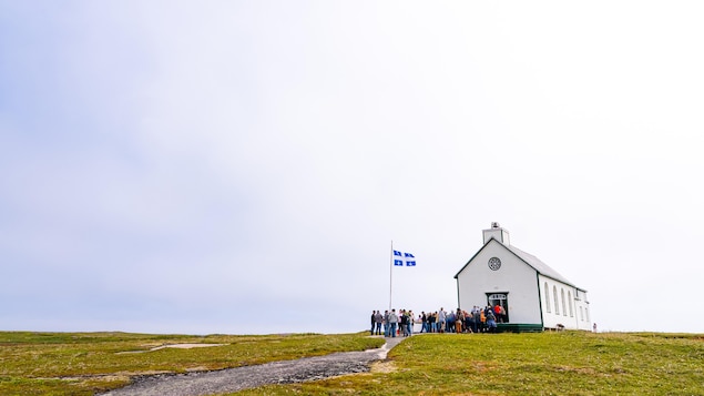 Une file de spectateur entrent dans une petite église sur l’île de la Providence.
