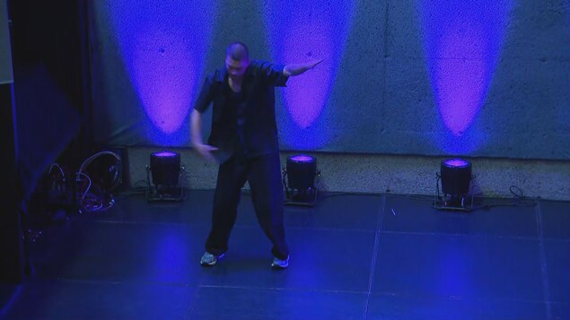 Un jeune homme danse sur une scène.
