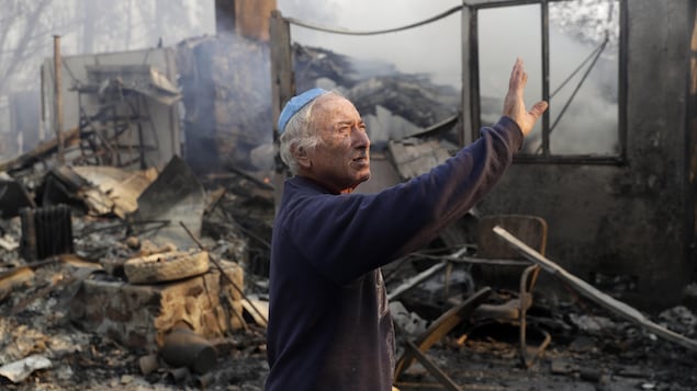 À Malibu, un homme observe les dégâts causés à une propriété par le passage d'un feu de forêt. À Malibu, un homme observe les dégâts causés à une propriété par le passage d'un feu de forêt.