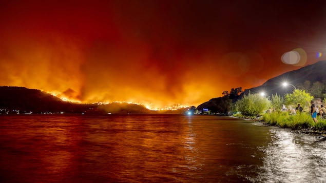 Un incendie ravage une vallée proche d'un lac.