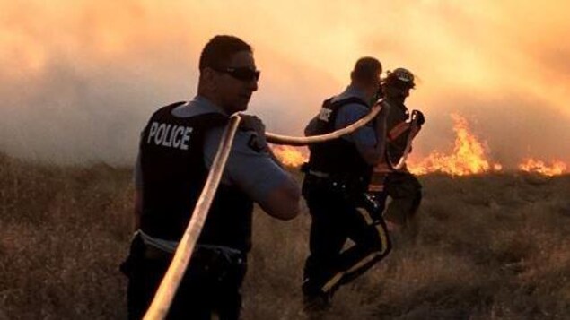 Des agents de la GRC aidant à lutter contre un incendie de forêt. 