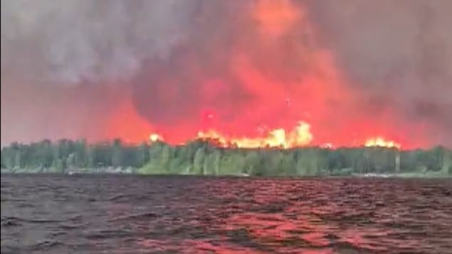 Un feu de forêt pris en photo depuis un lac en Ontario.