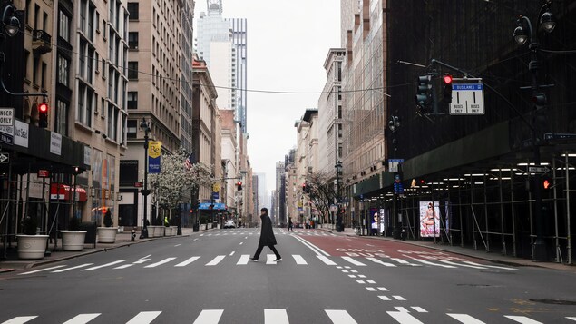 Un homme marche dans une rue déserte.