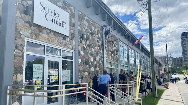 طابور مواطنين ينتظرون استلام جواز السفر الكندي أمام مكتب وكالة الخدمة الكندية في غاتينو في غرب مقاطعة كيبيك.
