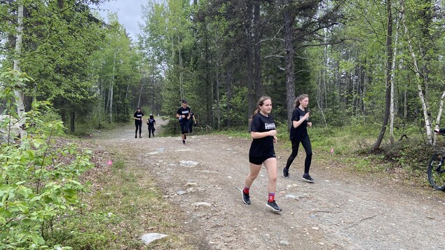Des filles courent en forêt.