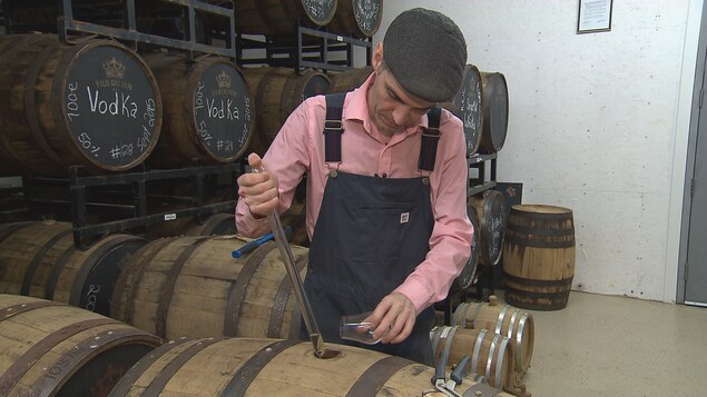 Sébastien Roy puise un alcool d'un baril Sébastien Roy puise un alcool d'un baril