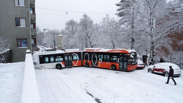 A bus in a snowy street. 