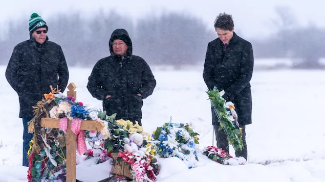 From left to right, Peter Chapman Band Chief Robert Head, James Smith Cree Nation Chief Wally Burns and Prime Minister Justin Trudeau stand in front of a grave of one of the victims of the mass stabbing incident at James Smith Cree Nation, Sask., on Monday.