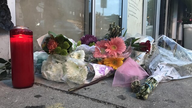 Photo de fleurs et d'une bougie sur le trottoir