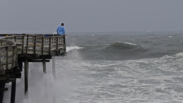 Des vagues se cassent sur la structure d'un quai en Caroline du Nord.