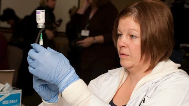 Licensed nurse practitioner Christine Melanson prepares doses of the H1N1 influenza vaccine at the Dr. Everett Chalmers Hospital in Fredericton, N.B. in 2009. The 2009 H1N1 pandemic continues to affect how younger ones do with flu, doctors say. (David Smith/The Canadian Press)