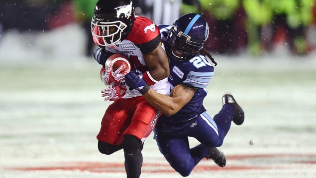 Roy Finch des Stampeders est plaqué par Rico Murray des Argonauts. Roy Finch des Stampeders est plaqué par Rico Murray des Argonauts.