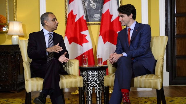 Justin Trudeau parle avec un homme d'affaires.