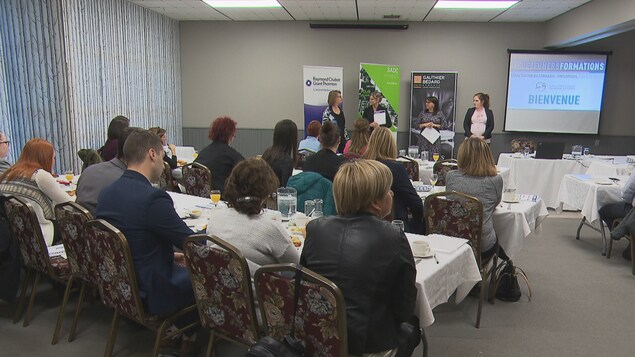 Des employeurs assis à des tables dans une grande salle Des employeurs assis à des tables dans une grande salle