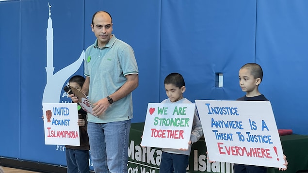 رجل وثلاثة أطفال يحملون لافتات.