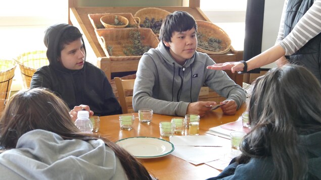 Deux adolescents regardent des graines dans la main d'un éducateur. Deux adolescents regardent des graines dans la main d'un éducateur.