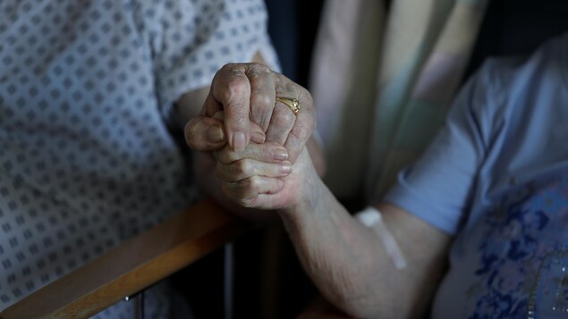 Un couple âgé se tient par la main dans un hôpital à Cambridge, en Grande-Bretagne, le 21 mai 2020.