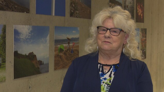 Francine Huet, participantes du projet « Une saison à la fois », devant un mur parsemé de photos de paysage. Francine Huet, participantes du projet « Une saison à la fois », devant un mur parsemé de photos de paysage.