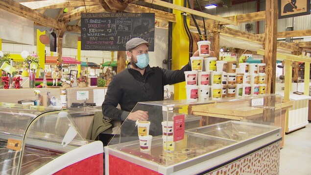 Franck Bouilhol place des pots de crème glacée sur son stand au marché fermier Bountiful.