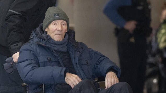 Un homme en fauteuil roulant avec une tuque et un manteau