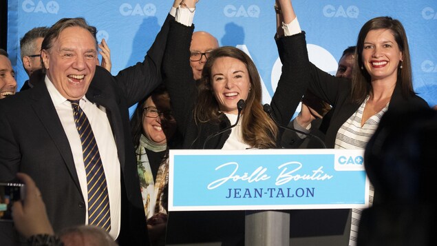 Trois personnalités politiques triomphantes sur une scène.