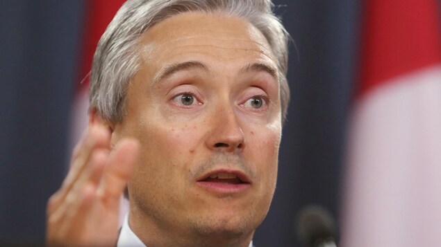 Le ministre parle, la main vers l'avant.