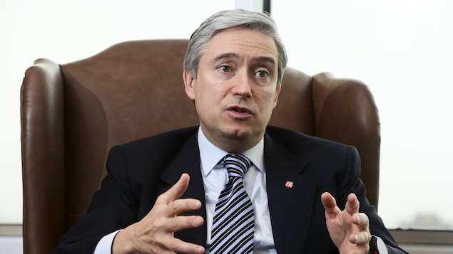 Assis dans un grand fauteuil, François-Philippe Champagne parle.