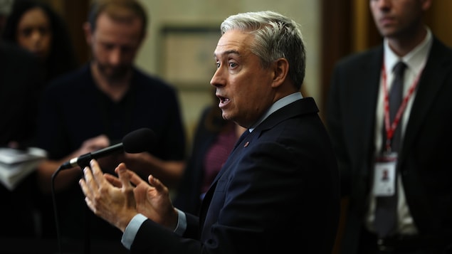 François-Philippe Champagne entouré de journalistes, en mêlée de presse.