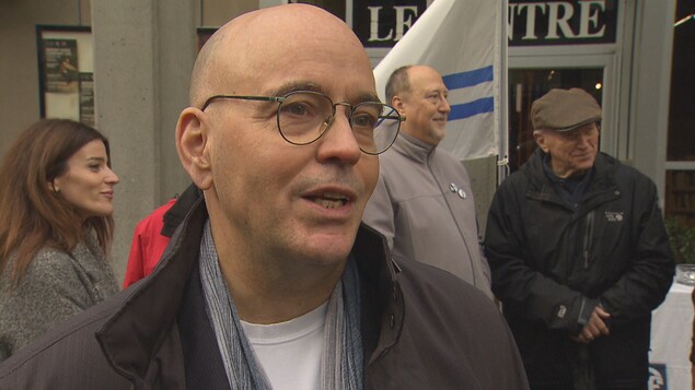 Robert Rothon manifeste devant un drapeau franco-colombien, dans une rue de Vancouver. Robert Rothon manifeste devant un drapeau franco-colombien, dans une rue de Vancouver.