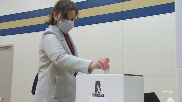 La fransaskoise Janie Moyen dépose son bulletin de vote dans une urne.