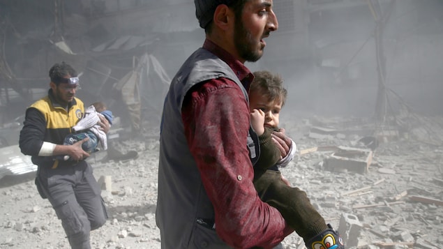Deux hommes transportent de jeunes enfants, dans un paysage de désolation. Deux hommes transportent de jeunes enfants, dans un paysage de désolation.