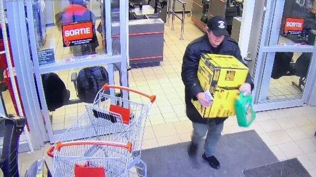 L'homme qui sort d'un commerce avec une boîte.