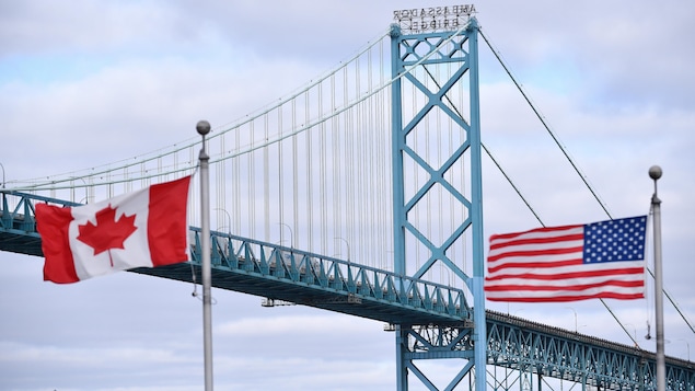 العلمان الكندي والأميركي يرفرفان فوق جسر.